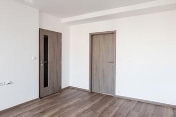 Empty flat after modern reconstruction with white walls and dark oak wooden floor
