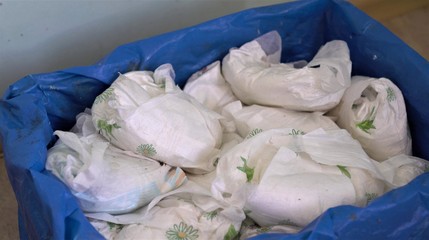 Used dirty diaper in the trash bin. Disposable nappies 