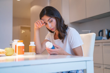 Tired woman with four bottles of pills stock photo