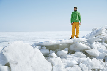 Fototapeta na wymiar Young adult man outdoors exploring icy landscape