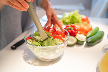 Person mixing salad in bowl stock photo