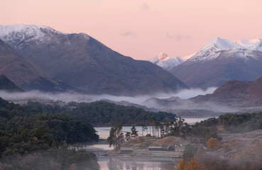 A beautiful sunrise overlooking Loch Affric in the Scottish Highlands. It was a cold winter morning with beautiful soft colors. In the background you can see the mountains covered in snow
