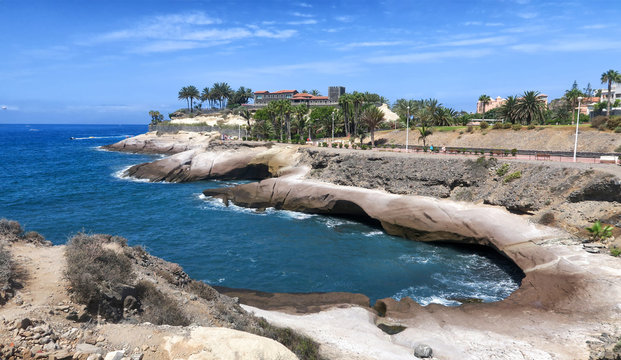 Promenade and pebble towers on the beaches of El Jard&iacute;n and El Beril beach.  of pebbles stacked on top of each other and round cobblestones build towers.