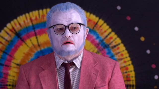 old mime man in big glasses with blue hair and beard in bright pink jacket and white gloves. happy clown depicts successive gestures. I don’t see anything, I don’t hear, I won’t say anything