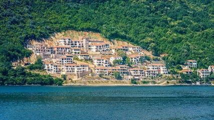 Fototapeta na wymiar A new housing development is cut out of forest land on the side of a hill in Montenegro.