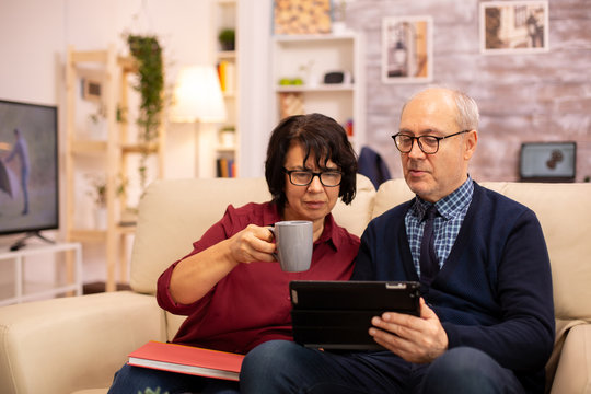 Beautiful old couple using a digital tablet to chat with their family
