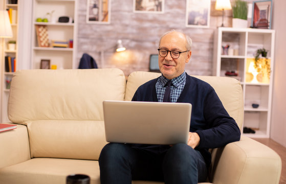Elderly old couple using modern laptop to chat with their grandson