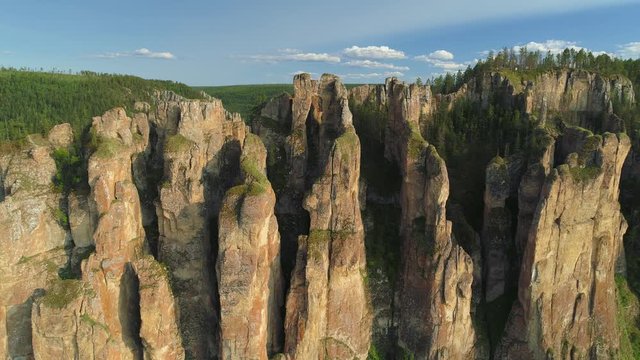 Lena pillars vertical high cliffs moss-covered peaks cinematic best sight Siberia Russia. Famous national park reserve. Untouched nature landscape open space horizon canyon taiga forest. Drone forward