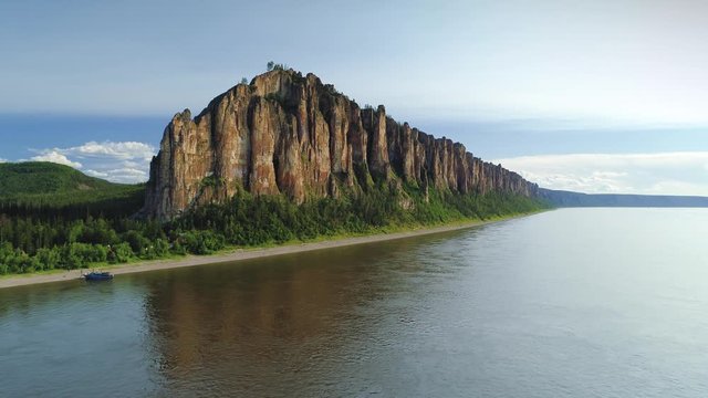 Flight forward Lena pillars vertical cliffs rock formation reflection in largest river cinematic landscape national park Yakutsk Russia natural monument World Heritage Site. Epic 4K