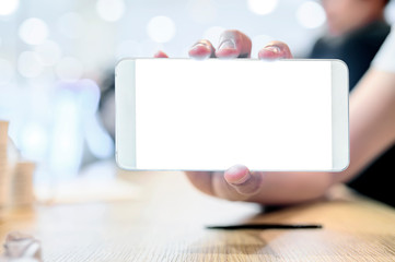 Obraz premium Closeup man hand holding smartphone with blank white screen while sitting at cafe.