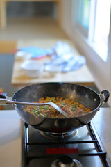 Close up hand and Spicy stir fried pork with red curry paste in pan.