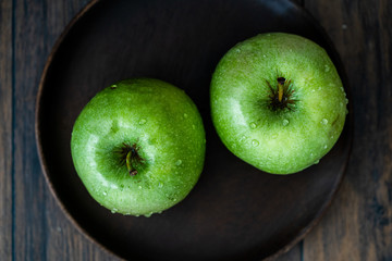 Granny Smith Organic GreenJuicy Apples on Dark Wooden Plate