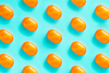 pattern of orange sweets on a blue background. background with bright orange sweets.