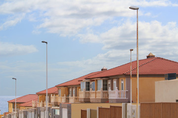 Colorful contemporary town houses covered with red roof tiles and with garages at the sea (Tenerife, Spain)