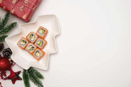 Sushi for christmas concept. Edible christmas tree mde from Philadelphia roll on white background. Food for christmas eve.