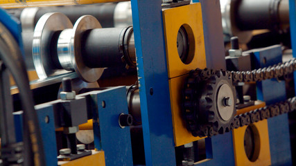 Fototapeta na wymiar Steel cog gear set of metal sheet bending machine in metalwork factory.
