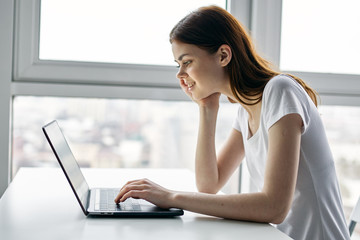 A woman is sitting at a laptop