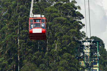 Fototapeta na wymiar Big cabin of the cable car .The red cabin of the ropeway with tourists in the Indian city Gangtok
