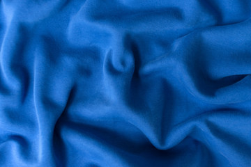 Blue fabric texture background. Textile cloth colored in trend classic blue color of the year 2020. Classic Blue Pantone color. Shallow depth of field, selective focus