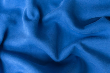 Blue fabric texture background. Textile cloth colored in trend classic blue color of the year 2020. Classic Blue Pantone color. Shallow depth of field, selective focus