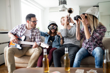 Cheerful friends having party together and playing instruments