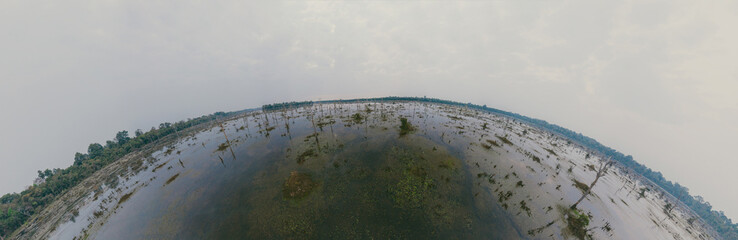 Lake with old trees sticking out of the water. 360 VR panorama drone shot. Cambodia near ancient...