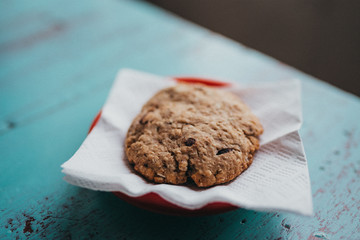 An oatmeal cookie on a red plate