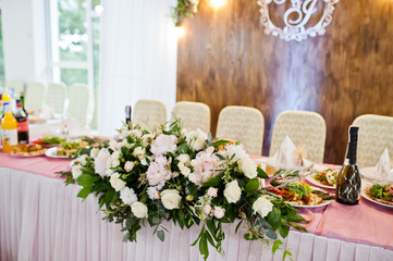 Beautiful wedding set decoration in the restaurant. Flowers on table of newlywed.