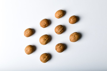 walnuts in symmetry. Close up view of walnuts. Walnuts are water, protein, fat and carbohydrates, including dietary fiber. In a reference portion of grams. A group of brown nuts arranged symmetrically