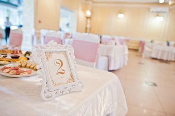 Beautiful wedding set decoration in the restaurant. Number 2 on table.