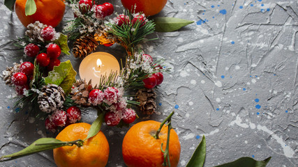 Fototapeta na wymiar mandarin. tangerines with leaves on a vintage wooden background. Green leaves of tangerines. Christmas tree branches and candles. copyspace