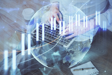 Forex graph with businessman working on computer in office on background. Concept of analysis. Double exposure.