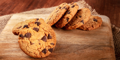 A panorama of chocolate chip cookies, gluten-free, on a dark rustic background with copy space