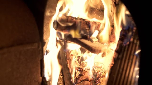 Fire burning wood logs with yellow and orange flames. Slow motion clip at half speed.