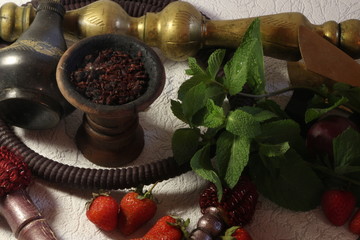 bowl with tobacco for hookah. fruits on a dark background. smoking hookah