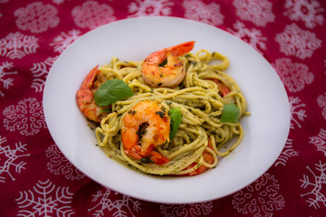 King prawns and pesto sauce with spaghetti on the red background