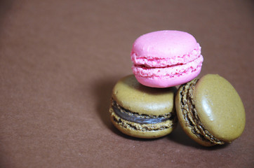 Colourful tasty macaroons in a row. macaroons of different colors on a brown background