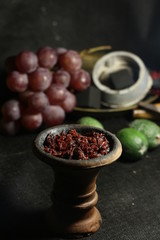 bowl with tobacco for hookah. fruits on a black background. smoking nargile