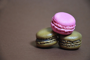 Colourful tasty macaroons in a row. macaroons of different colors on a brown background