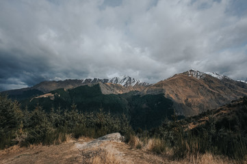 Fototapeta na wymiar Amazing view from Queenstown hills with snow capped mountains and pine forest.