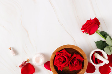Spa product with rose cream and.Rose petals on a marble background.