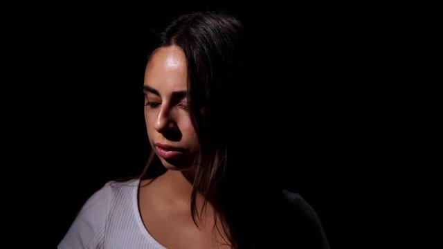 Sad and crying woman victim suffers from domestic violence in the family, sorrowfully looks at the camera and shows quietly, shhh. Domestic violence and social problems concept