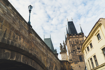 View of Lesser Town Bridge Tower at the end of Charles bridge, low shot from under bridge, sunny day in December