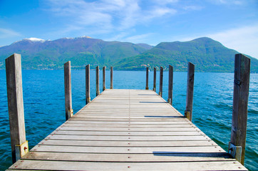 Pier and Mountain on an Alpine Lake Maggiore in Ticino, Switzerland.