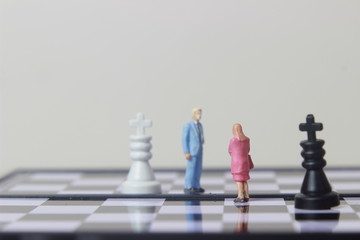 Simple illustration for photo War, Battle or politic situation concept, 2 standing mini figure, man and woman negoitation or debate beyond Small Magnetic Plastic chess