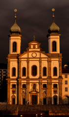 Fototapeta na wymiar Church (Jesuitenkirche) with Sunlight and Storm Clouds in Lucerne, Switzerland.