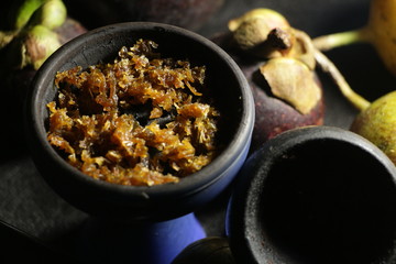 bowl with tobacco for hookah. fruits on a dark background. smoking shiisha