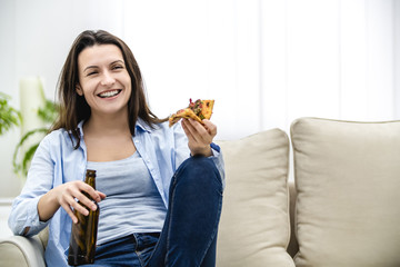 Young woman smiles sincerely and eat snack, watching movies. There is no time to be down. Enjoy life.