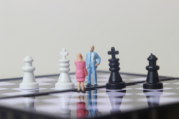 Simple illustration for photo War, Battle or politic situation concept, 2 standing mini figure, man and woman negoitation or debate beyond Small Magnetic Plastic chess
