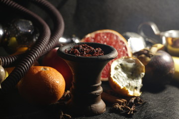 bowl with tobacco for hookah. fruits on a dark background. smoking nargile